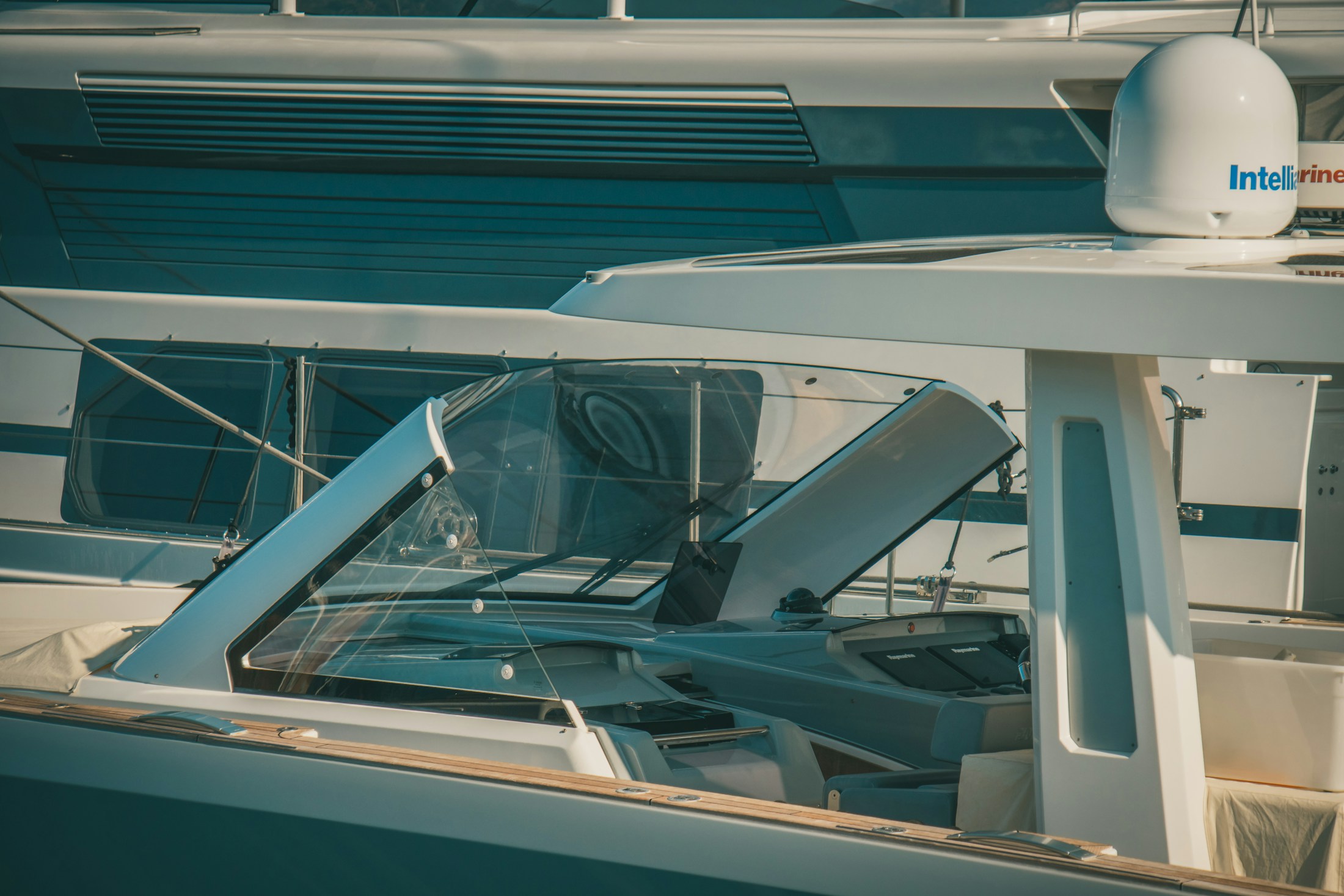 A modern yacht with broad cabin glazing beside the water