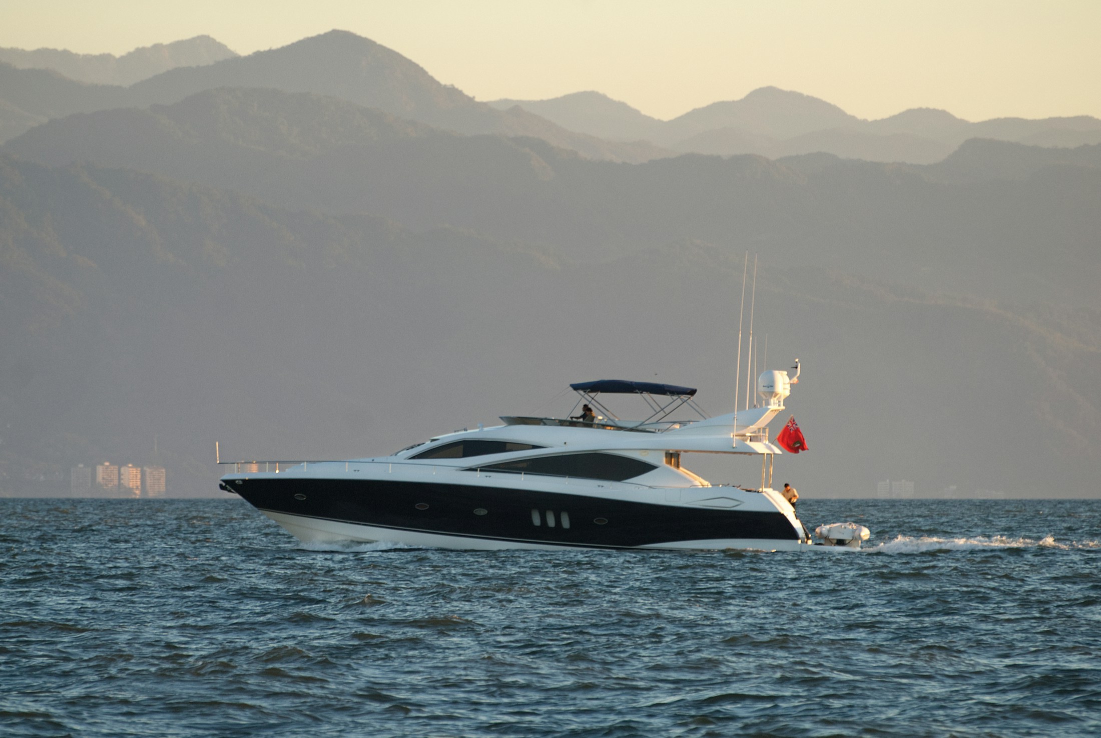 A yacht at sea, with its glazed cabin facing open water